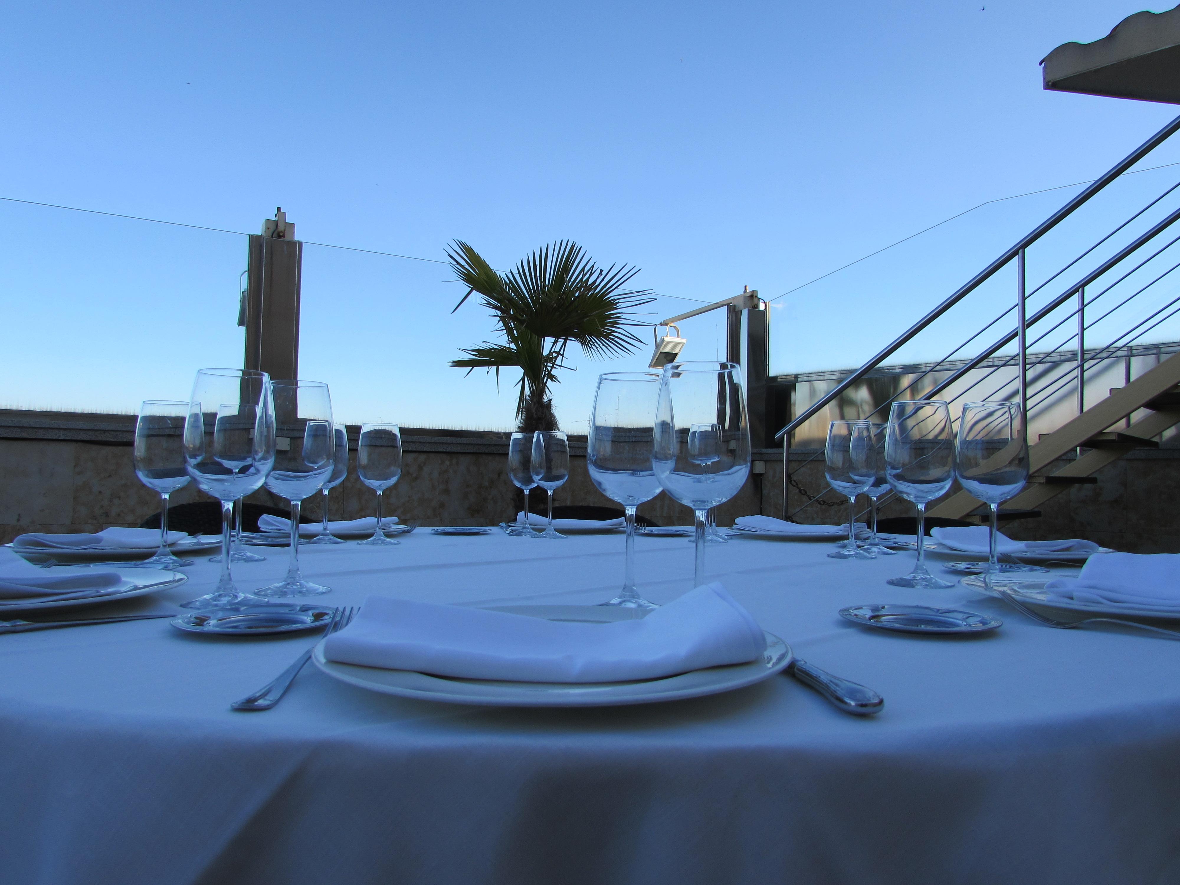 Hotel Alameda Palace Саламанка Экстерьер фото The photo depicts a beautifully set dining table outdoors. The table is covered with a white tablecloth and features several glassware pieces arranged with precision. There are multiple wine glasses and stemware, along with plates and silverware posi